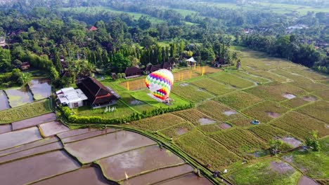 Setting-Up-Hot-Air-Balloon-For-Flying-over-Green-Fields-and-Rural-Nature-in-Ubud-Bali,-Drone-View