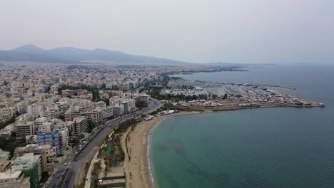 Port-Piraeus,-Athens-Greece-coastline-aerial-buildings-and-beach-Aegean-sea