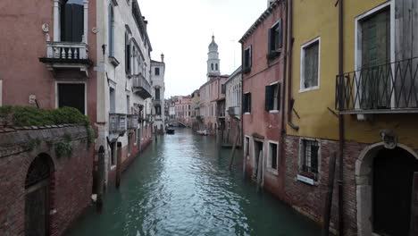 Perspective-shot-of-a-Heritage-canal-pass-in-Venice,-surrounded-by-colourful-historical-buildings