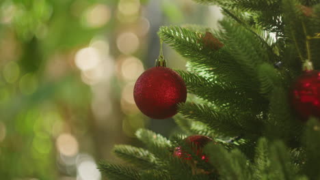 Rote-Kugeln,-Globen,-Hängen-Von-Einem-Roten-Weihnachtsbaum-Mit-Verschwommenem-Licht-Im-Hintergrund,-Ornamente-Und-Dekoration-Für-Die-Winterferien