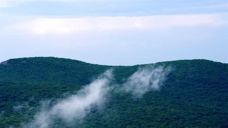 Die-Vergrößerte-Statische-Aufnahme-Zeigt-Dicht-Bewaldete-Hügel,-Die-Von-Tiefliegenden-Wolken-Umhüllt-Sind