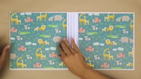 Gluing-the-decorative-paper-to-make-a-scrapbook-album-for-baby