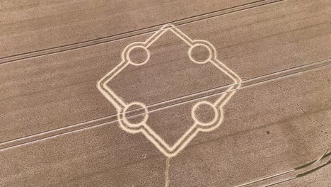 Stone-henge-square-crop-circle-formation-aerial-view-rising-above-golden-farmland-field-design