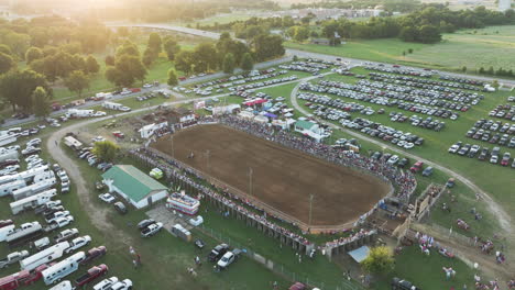 Aerial-footage-of-sunny,-vibrant-day-at-a-crowded-Siloam-Springs-rodeo-event