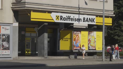 People-in-front-of-Raiffeisen-Bank-in-Havirov,-Czech-Republic,-static-shot