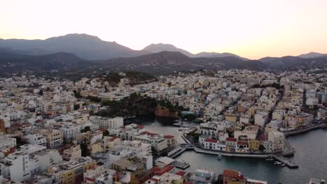 Right-Orbtial-Aerial-Panoramic-View-of-Agios-Nikolaos-Coastal-City-and-Voulisméni-Lake,-Crete,-Greece