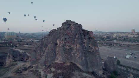 Vista-Aérea-De-La-Formación-Rocosa-De-Capadocia-Con-Globos-Aerostáticos-En-El-Cielo.