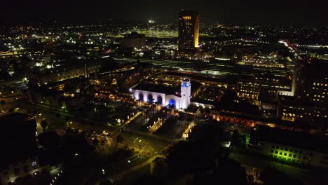 Experimente-La-Impresionante-Vista-Aérea-Nocturna-De-La-Union-Station-De-Los-Ángeles,-Que-Muestra-Su-Belleza-Iluminada-Y-El-Vibrante-Paisaje-Urbano-Circundante.