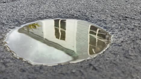 shadow-of-the-water-of-a-pit-on-the-ground-to-reflect-the-background-with-a-building-and-the-sky