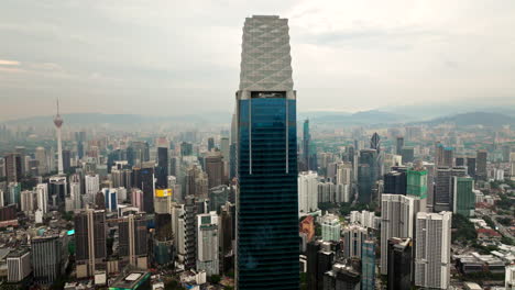 Aerial-arc-shot-around-iconic-The-Exchange-106-skyscraper-gracing-city-skyline