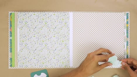 Timelapse-of-decorating-baby-themed-scrapbook-album-with-cutouts-and-stickers