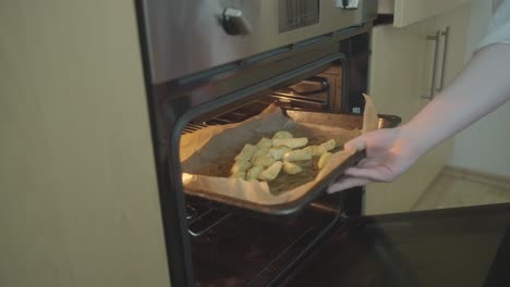 Putting-the-sliced-​​potatoes-in-the-hot-air-oven