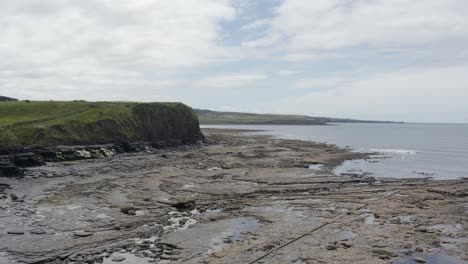 Flyover:-Exposed-low-tide-bedrock-shoreline-on-rocky-coast-of-Ireland