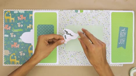 Adding-stork-sticker-to-baby-themed-scrapbook-album-layout-to-decorate-photo-area