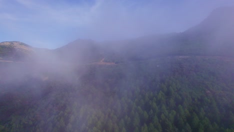 Luftflug-In-Die-Wolken-über-Grünen-Wäldern-In-Der-Bergkette