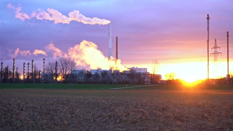 Sonnenaufgang-Hinter-Den-Schornsteinen-Einer-Chemiefabrik,-Gegenlicht-Und-Rauchemissionen