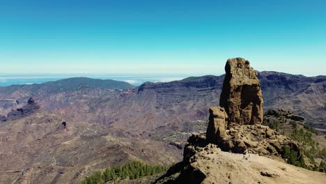 Aerial-view-of-people-hiking-in-Gran-Canaria-at-Roque-Nublo-mountain-geologic-rock-formation