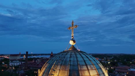 Drone-shot-of-a-golden-cross-onto-of-a-church-at-blue-hour-in-St