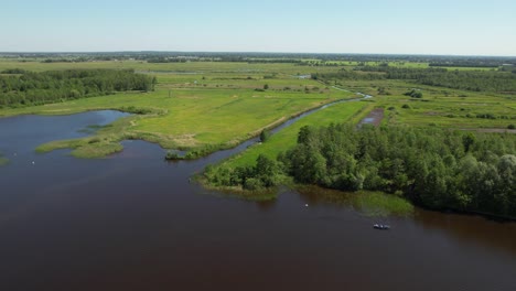 Vista-Aérea-Del-Paisaje-Verde-Y-El-Lago-En-El-Pueblo-De-Giethoorn-En-Un-Día-Soleado,-Países-Bajos