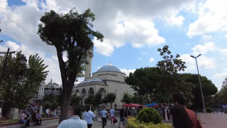 People-walking-in-the-pedestrian-area-near-Firuzaga-Mosque,-located-on-Divan-Yolu-Street,-Istanbul