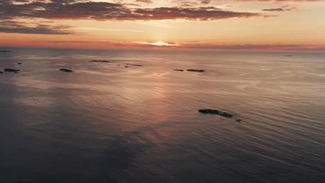 Aerial-view-of-calm-waters-and-islands-under-a-sunset-sky,-emphasizing-the-tranquility-and-beauty-of-the-scene