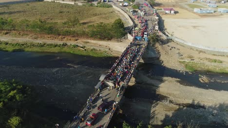 Haitianer-Warten-In-Der-Schlange-An-Einem-Grenzübergang-Auf-Einem-Fluss,-Um-Zum-Lebensmittelmarkt-Zu-Gelangen-Und-Lebensmittel-Und-Dinge-Des-Täglichen-Bedarfs-Zu-Kaufen