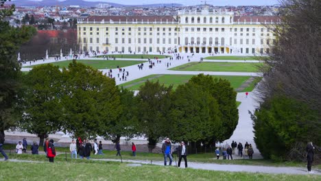 Vista-Lejana-Del-Palacio-De-Schönbrunn-Con-Turistas-Explorando-Sus-Jardines