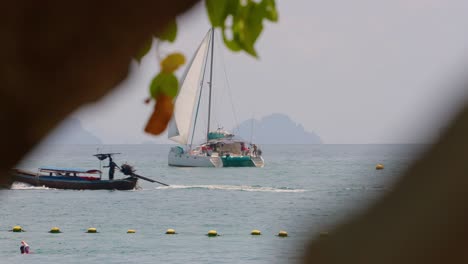 Passing-Long-Tail-Boat-With-Catamaran-In-Background,-Andaman-sea,-Thailand,-Asia