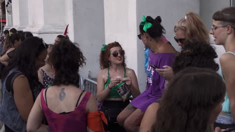 young-women-reunited-at-the-facade-of-Cabildo-in-Plaza-de-Mayo,-one-of-them-rolls-a-joint,-another-takes-a-picture-with-her-phone,-during-peaceful-abortion-rally