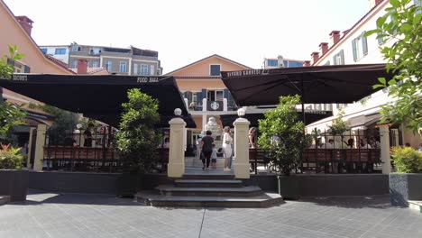 View-of-Narmanli-Han,-a-17th-century-historical-building-on-Istiklal-Street,-now-a-shopping-mall-and-cultural-center-with-a-central-courtyard-surrounded-by-shops-and-a-fountain