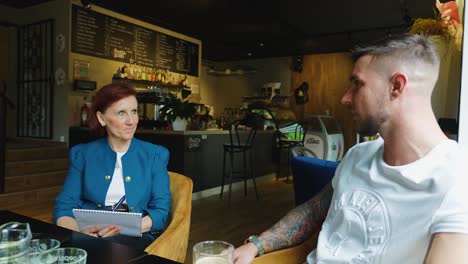 Gente-Hablando-En-Una-Cafetería,-Toma-De-Rotación-En-Cámara-Lenta