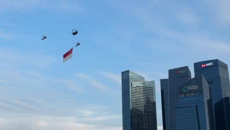 Schwerlasthubschrauber-Tragen-Die-Staatsflagge-Und-Fliegen-Eskortiert-Von-Zwei-Apache-Kampfhubschraubern-über-Das-CBD-Während-Der-Probenparade-Zum-Nationalfeiertag-In-Singapur