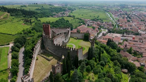 Vista-Aérea-Del-Histórico-Castillo-De-Soave-Rodeado-De-Exuberante-Vegetación-Y-Viñedos-En-Italia