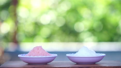 a-small-bowl-of-himalayan-salt-and-sea-salt-with-blur-nature-background