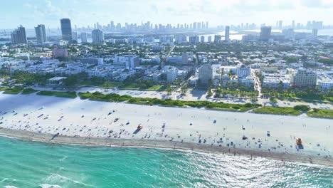 A-drone-flies-parallel-to-Miami-Beach-at-400ft,-showing-the-water,-beach,-South-Beach-city,-and-Miami-downtown-skyline-in-the-background