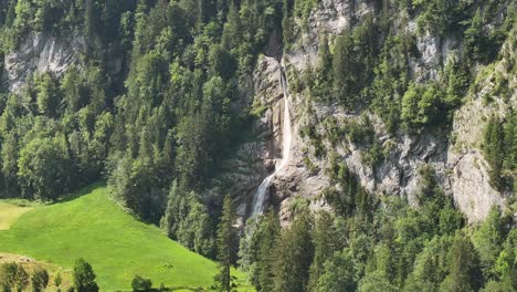 Aerial-view-of-a-waterfall-cascading-from-the-cliffs-of-Klöntal-in-Glarus-Süd,-Switzerland,-capturing-the-concept-of-dramatic-natural-beauty-and-rugged-landscapes