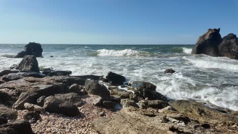 Waves-crash-against-rocky-shores-as-the-sun-shines-over-the-beautiful-coastline-of-Crimea,-creating-a-breathtaking-seaside-experience