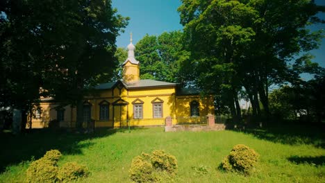 Malerische-Gelbe-Russisch-orthodoxe-Kirche-Inmitten-Grüner-Bäume-In-Einer-Sommerlandschaft