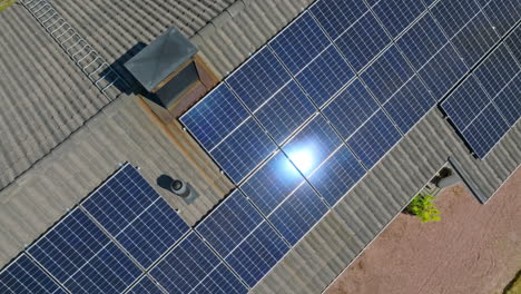 High-angle-drone-shot-circling-mirroring-solar-modules-on-a-off-grid-house