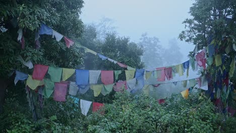 Neblig-blaue-Buddhistische-Gebetsfahnen-In-Nepal,-Religiöse-Gebetsfahnen-Im-Nebel-Und-Natur-In-Waldlandschaft-In-Nebliger,-Launischer,-Blauer-Atmosphärischer-Stimmungsszene-Im-Himalaya-In-Ruhiger,-Friedlicher-Szene