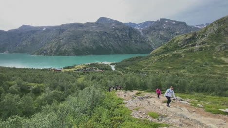 People-hiking-at-Besseggen-mountain-in-Norway-with-beautiful-scenery-of-a-green-lake-in-the-background