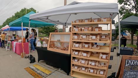 Langsame-Schwenkung-Eines-Sauerteigbäckereistandes-Auf-Dem-örtlichen-Bauernmarkt-Mit-Schwenkung-Zu-Anderen-Ständen