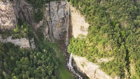 Stunning-Aerial-Dolly-in-Shot-of-White-Waterfall-Cascading-Lush-Green-Forest