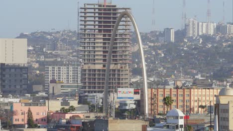 Die-Skyline-Von-Tijuana,-Die-Von-Einem-Modernen-Bogen-Und-Aufragenden-Wolkenkratzern-Dominiert-Wird,-Spiegelt-Die-Rasante-Urbane-Entwicklung-Der-Stadt-Und-Ihre-Rolle-Als-Dynamische-Grenzstadt-Wider