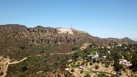 Aerial-establishing-shot-of-Hollywood-Sign-with-luxury-villas-an-mansion-in-the-Hollywood-Hills-next-to-Griffith-Park