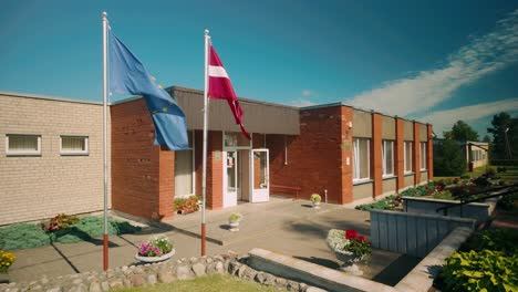 Kaplava-parish-administration-municipality-house-with-EU-and-Latvian-flags-waving-in-the-summer-breeze