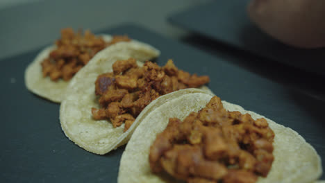 Beautiful-zoom-out-shot-of-a-line-of-Mexican-tacos-or-“cochinita”-tortillas-lined-up-in-an-industrial-kitchen-inside-a-Mexican-restaurant