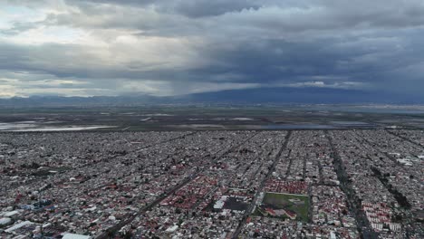 Vista-Aérea-Del-Valle-De-México,-Con-La-CDMX-A-Lo-Lejos,-Durante-Un-Día-Nublado-Y-Lluvioso.