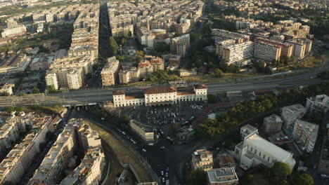 Drone-Se-Inclina-Hacia-Abajo-Para-Establecer-Una-Estación-De-Tren-En-Medio-Del-Barrio-De-Trastevere,-Roma,-Italia,-Al-Atardecer