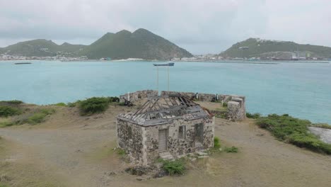 Toma-Aérea-Panorámica-Que-Captura-El-Antiguo-Fuerte-De-Ámsterdam,-San-Martín,-Con-Colinas-Verdes-Al-Fondo